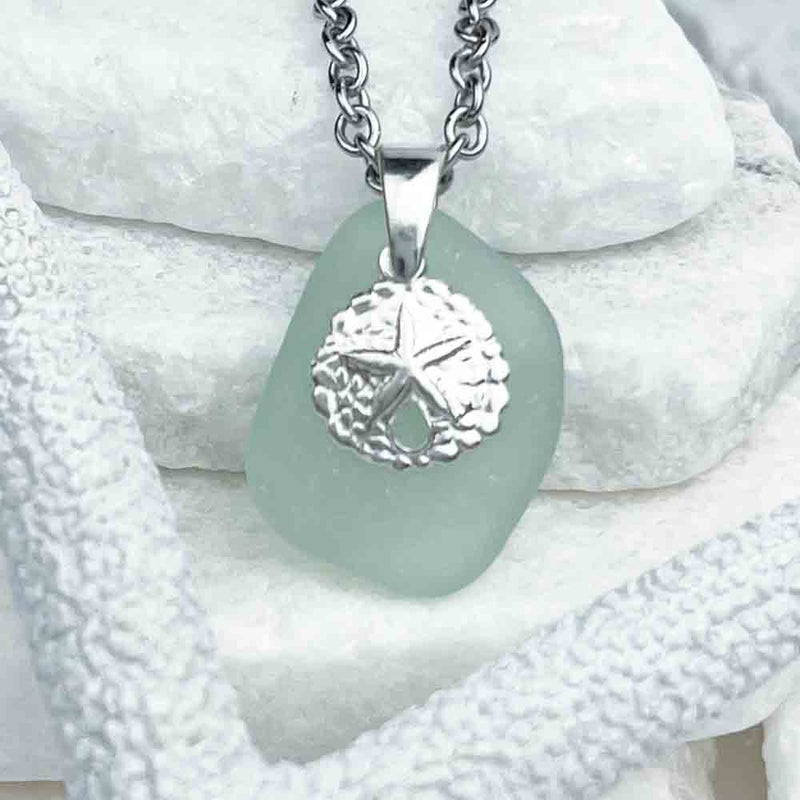 An Inspiring Seafoam Sea Glass Pendant Partnered with a Sand Dollar Charm|View the entire collection of guaranteed authentic Sea Glass! Real Sea Glass Necklaces | Bracelets | Earrings | Rings | Rare Colors Our Specialty | 30+ Years Experience