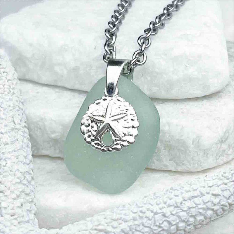 An Inspiring Seafoam Sea Glass Pendant Partnered with a Sand Dollar Charm|View the entire collection of guaranteed authentic Sea Glass! Real Sea Glass Necklaces | Bracelets | Earrings | Rings | Rare Colors Our Specialty | 30+ Years Experience