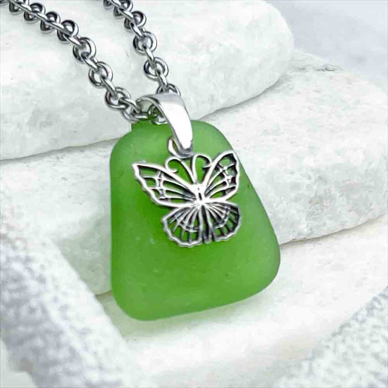 This Playful Green Sea Glass Pendant is Topped with a Delightful Butterfly Charm  | View the entire collection of guaranteed authentic Sea Glass| Real Sea Glass Necklaces| Bracelets| Earrings| Rings| Rare Colors Our Specialty| 30+ Years Experience 